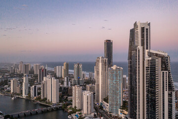 Drone view of modern city at dusk with ocean. Tourism and travel. Gold Coast, Queensland, Australia