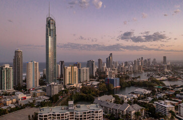 Drone view of modern city at dusk with ocean. Tourism and travel. Gold Coast, Queensland, Australia