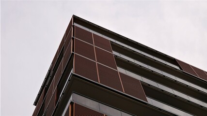 corner of facade of modern residential building with balconies against the sky