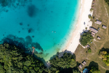Drone view of sandy beach and green shore near turquoise sea. Tourist settlement. Sanma, Vanuatu.. - obrazy, fototapety, plakaty