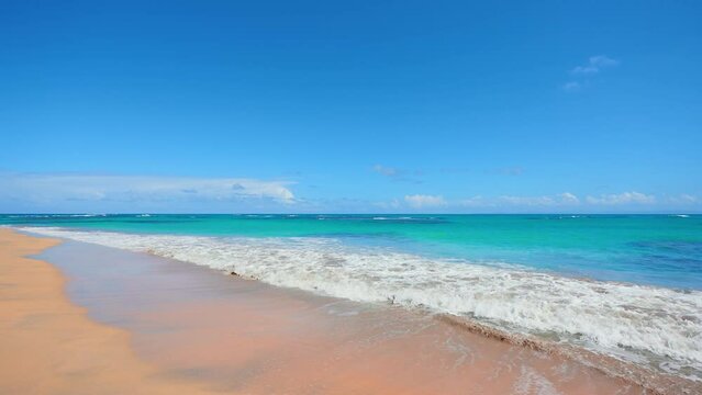 Large calm waves of the Caribbean Sea against a blue sky with white clouds. Seascape view from the beach. Rest and vacation concept. Vacations holidays on the sunny tropical coast. Cruise.