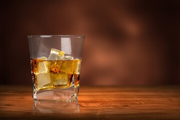 Glass of cold alcohol drink on wooden desk