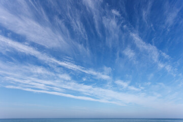 Beautiful blue sky over the sea with translucent, white, Cirrus clouds