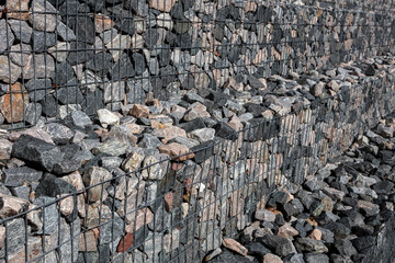 A stepped wall of gabions. Shot from an angle.