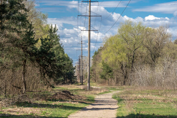 Electricity transmission towers and power lines in forest. High voltage pole on road. Energy...