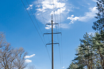 Electricity transmission towers and power lines in forest. High voltage pole on road. Energy...