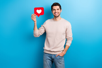 Portrait of nice young man hold paper like notification card wear beige sweatshirt isolated on blue color background