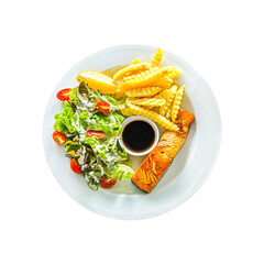 Succulent grilled salmon fillet sits beside salad and French fries on white plate, accompanied by a...