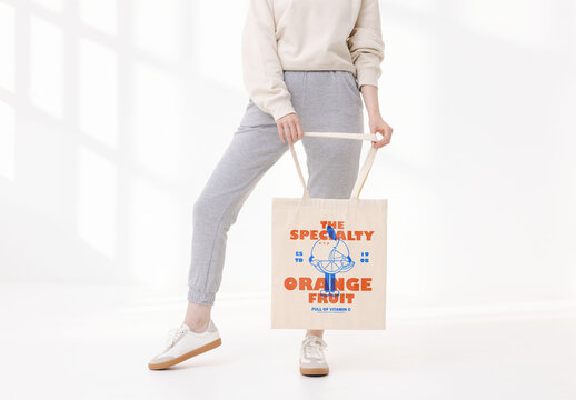 Mockup of woman holding customized tote bag, low section