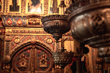 Censers hang in a row against the backdrop of an expensively decorated altar with icons. Everything...