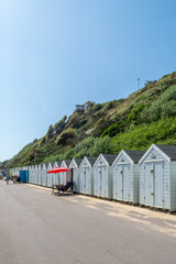 West Cliff Beach, Bournemouth, UK - May 26th 2023: A man relaxing outside his beach hut.