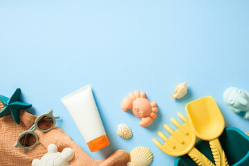 Sunscreen cream, beach toys and baby accessories on blue background. Flat lay, top view.