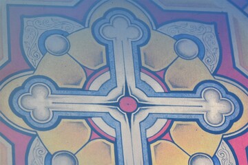 Stained glass window with a cross on the background of stained glass