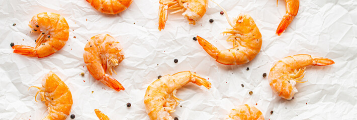 Roasted or grilled shrimps with seasonings top view on baking paper, healthy snack or appetizer....