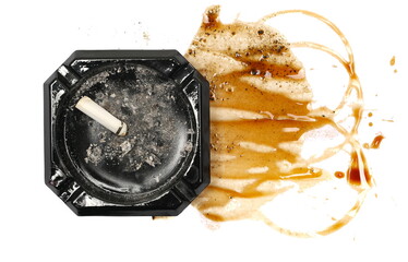 Cigarette butt in black ashtray and spilled coffee espresso with foam, stains isolated on white background, top view