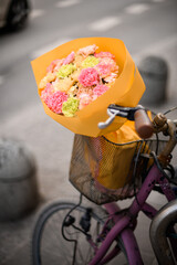 Street photo of delicate carnations and bicycle on a city street