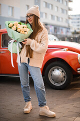 Tenderness girl in knitted sweater, blue jeans and sneakers and vintage car - 791931581