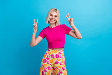 Photo portrait of lovely young lady show v-sign gesture dressed stylish pink clothes isolated on blue color background