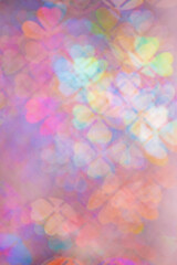 Floral figured Bokeh in purple Hues, Colorful Abstract bokeh background, natural flare from lights, blurred clover leaves shapes texture as holiday backdrop, celebration idea with optical effect