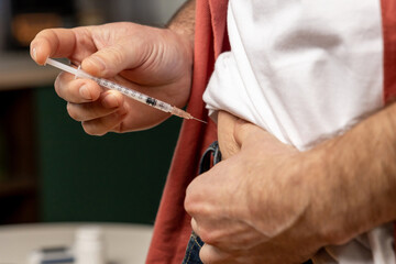Unhealthy unrecognizable man with syringe making insulin injection by himself