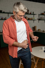 Unhealthy man with syringe making insulin injection by himself