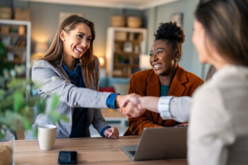 Business women shaking hands. Recruitment concept to hiring of a new talented specialists for an international company. - obrazy, fototapety, plakaty