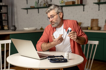 Online medical consultation for diabetic patient man with glucometer via laptop