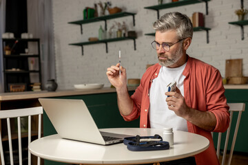 Diabetic patient man holding glucose meter using laptop having online medical consultation