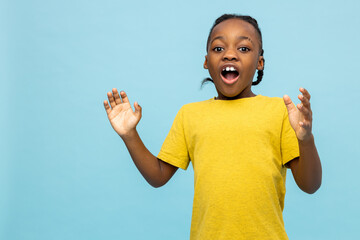 Excited dark- skinned little boy exclaiming something with raised arms