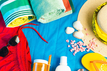 Straw hat, red bikini and exotic cold drinks designed on blue towel surface. Summer concept