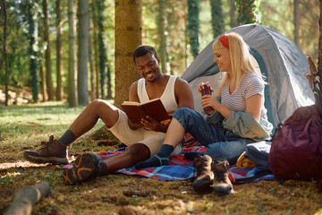 Young happy couple enjoying in camping in woods.