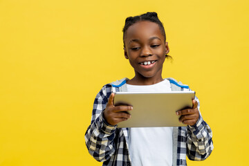 African american boy in checkered shirt with tablet in hands