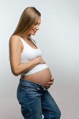 Smiling pregnant woman in jeans and white tshirt - 791962509