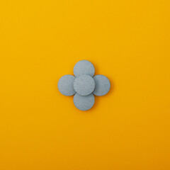Light blue pigments in tablets on yellow background. Dyes or Food additives for coloring food...