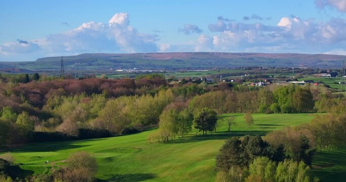 Aerial video of Heaton Park, Greater Manchester UK showing wind turbines on the Horizon