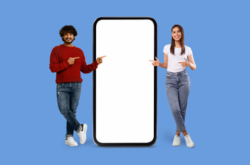 Naklejka premium Casual Multiracial couple with oversized smartphone mockup