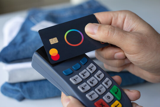Man hand card Payoneer Mastercard and pay online POS terminal