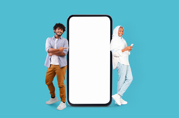 Pair smiling beside smartphone layout on blue