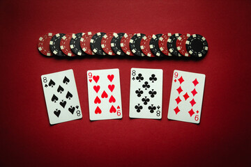 Chips and playing cards with a winning combination of two pairs on a red table. Concept of luck or winning in poker club. Winning at a casino depends on luck
