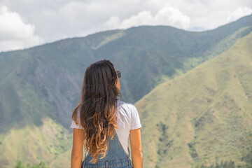 Young woman looking at the horizon from a mountain top
