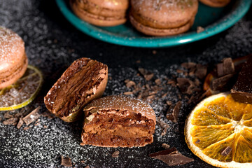Macaroons with chocolate cream on a dark background