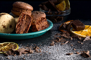Macaroons with chocolate cream on a dark background