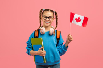 Smiling schoolgirl with Canadian flag on pink background