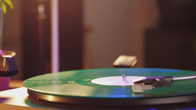 Retro Vinyl record player playing music, close-up macro shot of vintage LP disc old phonograph spinning. Retro music player at home.