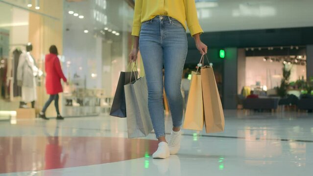 Front view woman walking going with bags shopping mall buy unrecognizable shopaholic sale boutique store discount fashionable style brand trendy clothes black friday new collection spend money things