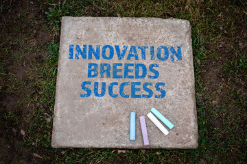 INNOVATION BREEDS SUCCESS. Colored pieces of chalk on a concrete pavement slab - 792001959