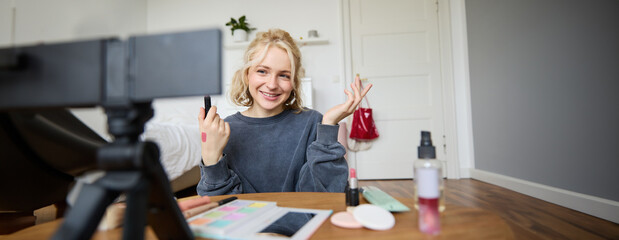 Image of young stylish woman, blogger recording a beauty lifestyle video of her picking best...