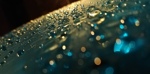 Gotas de agua en superficie de metal iluminadas con luz, imagen creativa