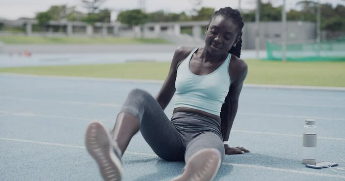 Happy black woman, fitness and stretching legs on stadium track for workout, exercise or outdoor training. African female person, runner or athlete in warm up stretch or getting ready for running