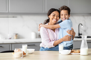 Happy mother and son hugging in kitchen